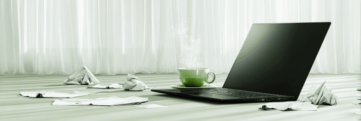 A steaming cup of tea sits beside a closed laptop on the floor, surrounded by crumpled and scattered papers. Soft white curtains diffuse the daylight, creating a quiet, post-creative atmosphere.