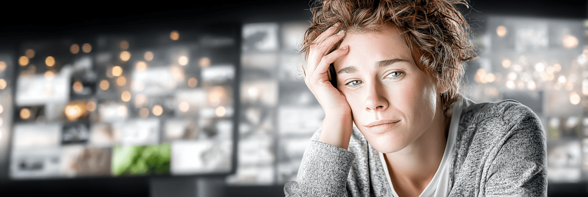 A tired person resting their head in their hand while surrounded by glowing blurred digital screens and endless streams of online content and notifications.
