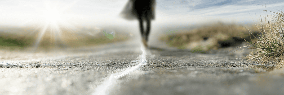 A person steps across a faint line on a sunlit path, symbolizing the decision to move beyond imagined limits and expectations.